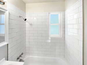 Bathroom with tiled shower / bath and plenty of natural light