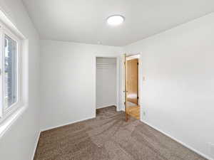 Unfurnished bedroom featuring carpet and a closet