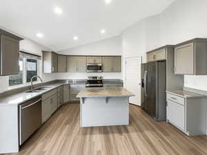 Kitchen with gray cabinets, a center island, stainless steel appliances, and sink