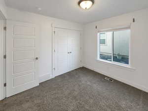 Unfurnished bedroom featuring carpet floors and a closet