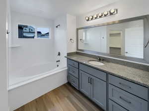 Bathroom with vanity, shower / tub combination, and wood-type flooring