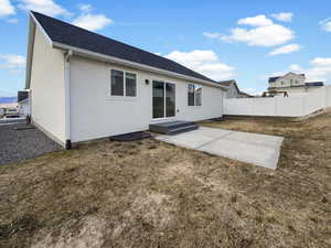 Back of property with a patio and a lawn