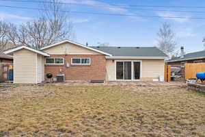 Back of house featuring a yard, central air condition unit, and a patio area