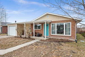 View of front of property with a porch and a garage