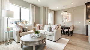 Living room with a notable chandelier and light hardwood / wood-style flooring