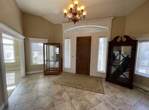 Foyer entrance featuring lofted ceiling and a notable chandelier