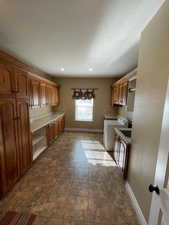 Kitchen with washing machine and dryer, built in desk, and a textured ceiling