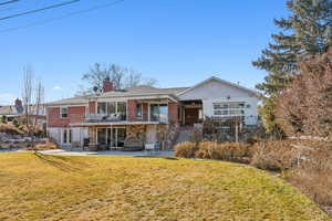 Back of property with a patio, a lawn, ceiling fan, and a balcony