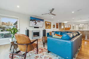 Living room featuring light hardwood / wood-style floors and ceiling fan with notable chandelier