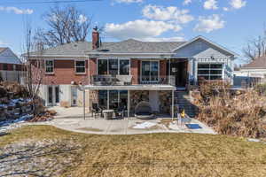 Rear view of property featuring a patio, a balcony, and a lawn