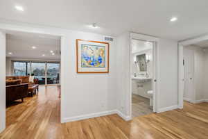 Corridor with light hardwood / wood-style flooring