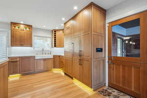 Kitchen featuring light wood-type flooring, sink, and backsplash