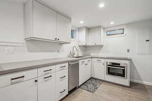 Kitchen featuring sink, white cabinets, electric panel, and stainless steel appliances