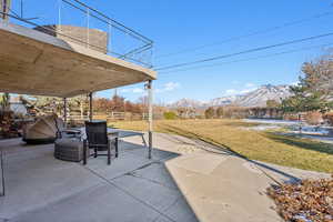 View of patio with a mountain view and a balcony