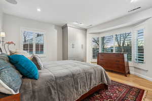 Bedroom featuring hardwood / wood-style floors and multiple windows