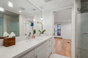 Bathroom featuring vanity, wood-type flooring, and a shower with shower door