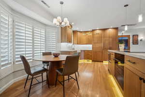 Dining area featuring a notable chandelier, sink, and light wood-type flooring