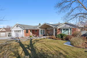 Ranch-style house with a garage and a front lawn