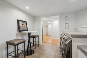 Bar featuring light hardwood / wood-style floors and separate washer and dryer