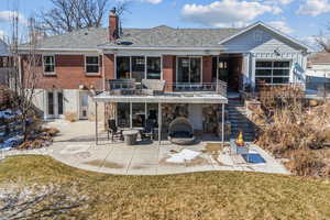 Rear view of house featuring a yard, a patio, and an outdoor fire pit