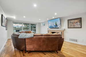 Living room featuring light wood-type flooring and a brick fireplace