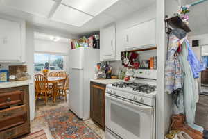 Kitchen with white cabinetry and white appliances