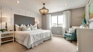 Carpeted bedroom featuring a notable chandelier