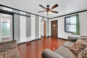 Living room featuring crown molding, dark hardwood / wood-style floors, and ceiling fan