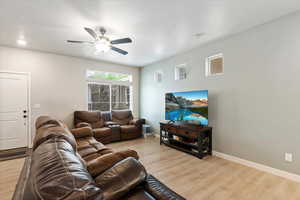 Open living room featuring light wood-style laminate floors