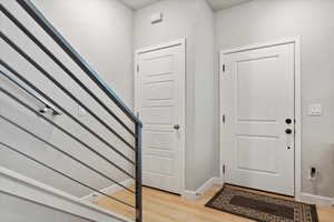 Entrance foyer with light wood-style laminate flooring & coat closet