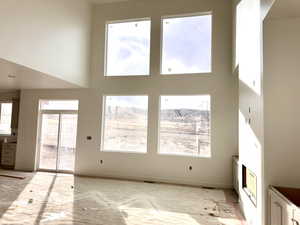 Unfurnished living room with a towering ceiling