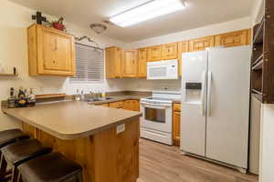 Kitchen featuring wood appliances, wood-style flooring and breakfast bar