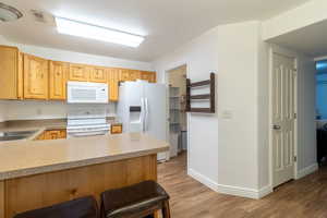 Kitchen featuring wood appliances, wood-style flooring and breakfast bar