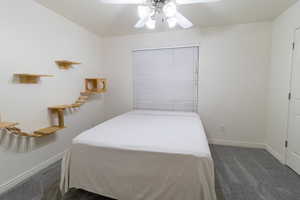 Carpeted bedroom featuring ceiling fan