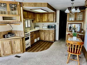 Kitchen with dark hardwood / wood-style flooring, decorative light fixtures, sink, and white range oven