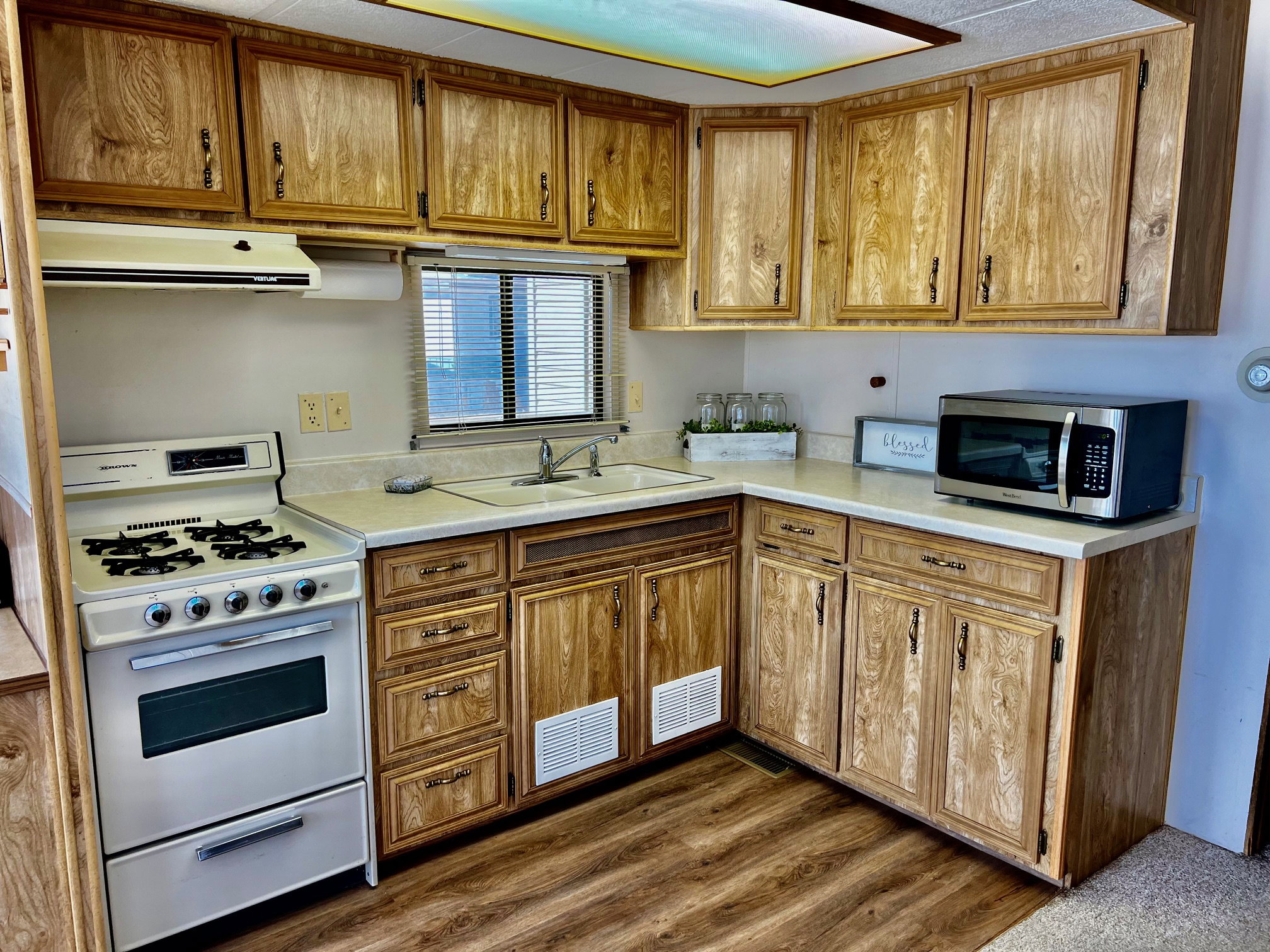 Kitchen with sink, gas range oven, and dark hardwood / wood-style floors