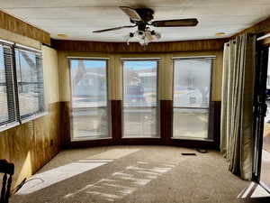 Unfurnished sunroom featuring ceiling fan