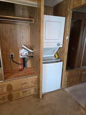 Laundry area with carpet and stacked washer and clothes dryer