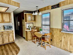 Dining area with wooden walls and light colored carpet