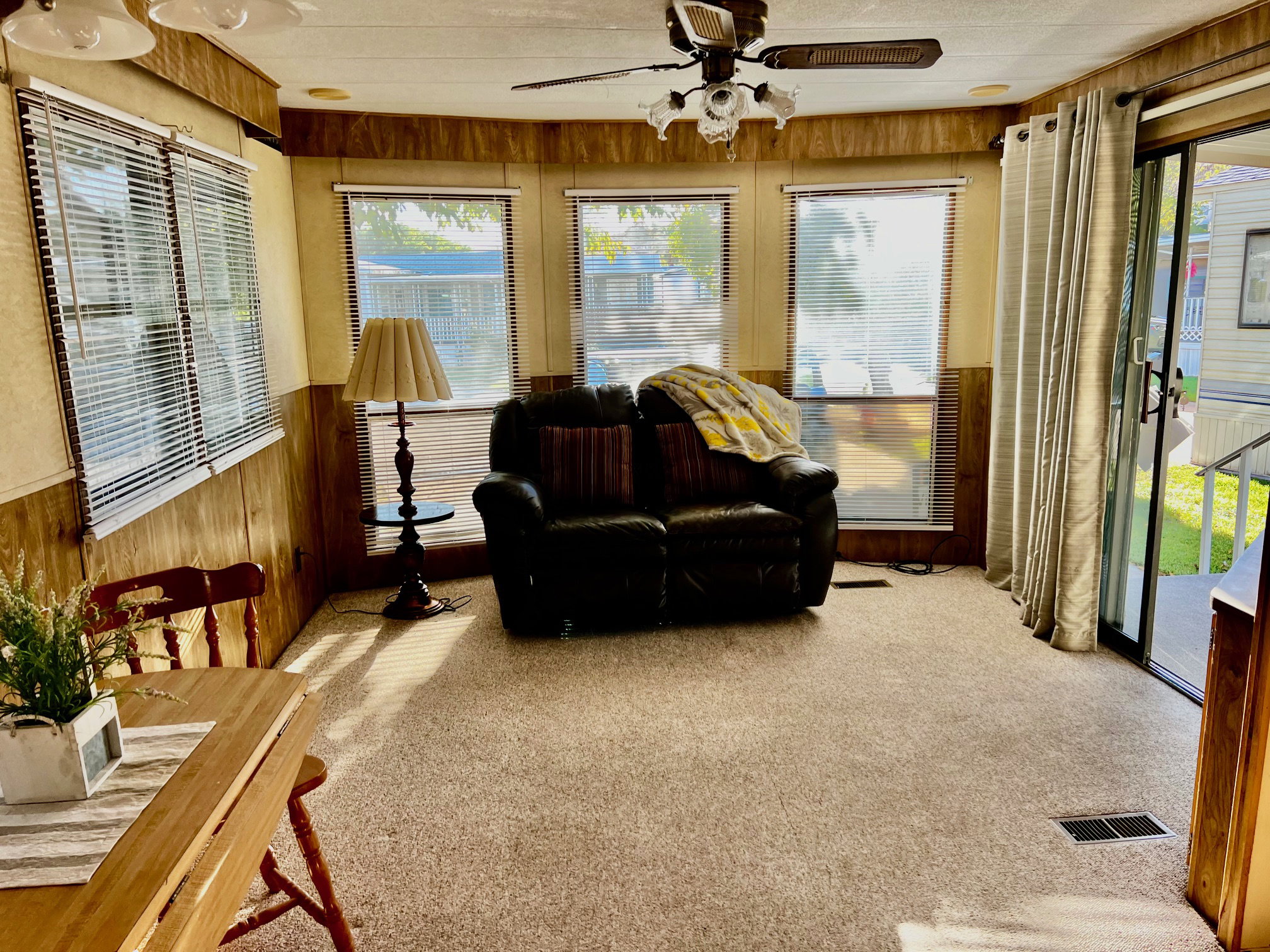 Sunroom featuring wooden walls, carpet flooring, and wainscoting