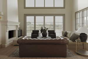 Living room with a towering ceiling and light hardwood / wood-style flooring