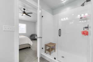 Bathroom featuring ceiling fan and a shower with shower door