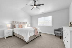 Bedroom with light carpet, vaulted ceiling, and ceiling fan