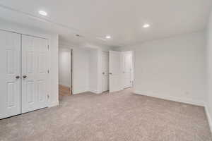 Unfurnished bedroom featuring two closets and light carpet