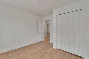 Unfurnished bedroom featuring light hardwood / wood-style floors and a closet