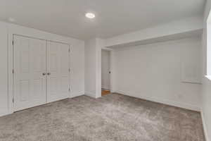 Unfurnished bedroom featuring light carpet and a closet