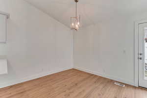 Interior space with light wood-type flooring and a chandelier