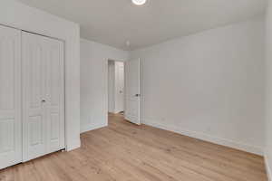 Unfurnished bedroom with light hardwood / wood-style flooring and a closet