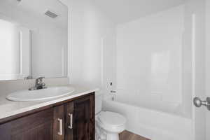 Full bathroom featuring vanity, toilet, and  shower combination