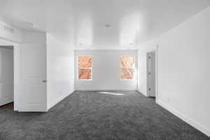 Carpeted spare room featuring a textured ceiling